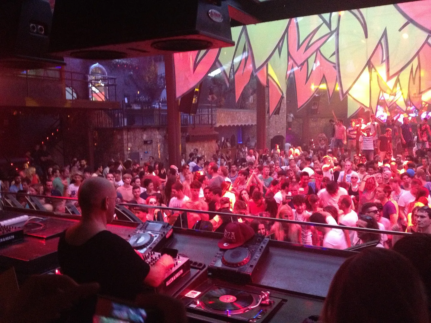 A packed Amnesia dancefloor under orange lights and lasers during Sven Väth’s Cocoon set in 2013